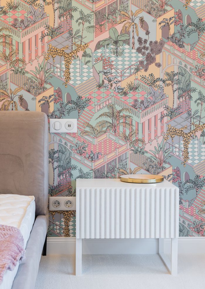 Pastel illustrated mural wallpaper of terraced gardens behind a white ribbed nightstand